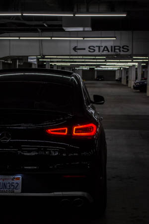 黑色Mercedes-AMG SUV在黑暗停車場中帶有發光紅色尾燈。