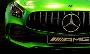 充滿活力的綠色 Mercedes-AMG 汽車前格柵，帶有鍍鉻標誌和徽章。 — 汽車 壁紙