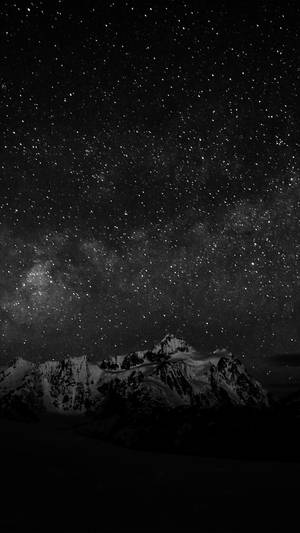 積雪的山峰在可見銀河的星空下。