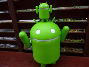 木長凳上嘅綠色Android吉祥物公仔，頭頂有細Android。