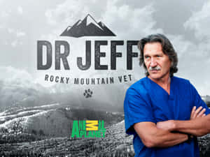 穿著藍色手術服的獸醫Dr Jeff交叉雙臂站在雪山背景下。