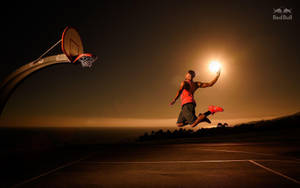 運動員在半空中拿著發光的球靠近籃框，夜間 — 奇雲·哈特 壁紙