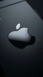 黑色設備上Apple標誌特寫，表面光澤
