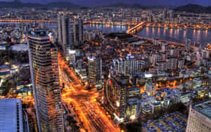 繁華城市的夜間鳥瞰圖，閃爍的建築物和交通光跡。