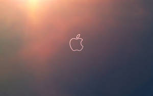 Apple標誌輪廓在日落漸變背景上發光。