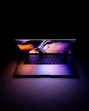時尚筆記型電腦在昏暗燈光下顯示充滿活力的抽象壁紙。