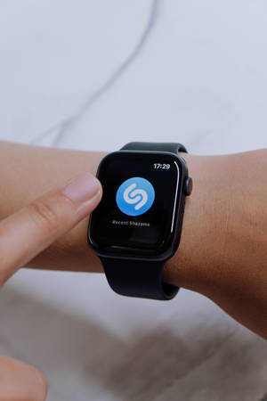 一個人的手腕戴著智能手錶，顯示Shazam應用程式結果。