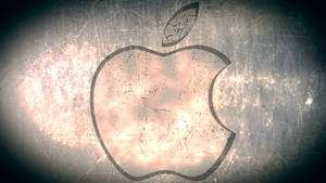 刮花金屬上的Apple標誌，中心發光，邊緣暗色。