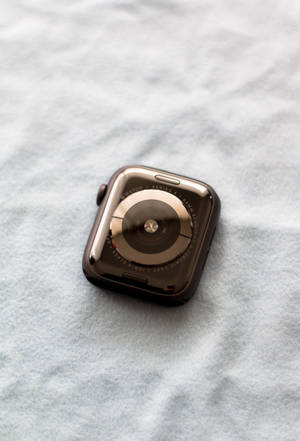 灰色織物背景上的黃金Apple Watch — iPhone 4K 壁紙
