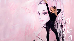 Ariana Grande 身穿黑色服裝，在一個粉紅色壁畫前擺姿勢，壁畫上是她的臉。 — 愛莉安娜·格蘭德 壁紙