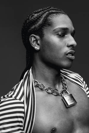 編辮子的男子，身穿條紋襯衫，戴著 Chanel 掛鎖項鍊。