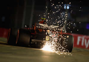 Aston Martin F1 賽車在夜間行駛，輪胎冒出火花。 — 賽車 壁紙