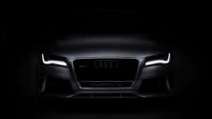 Audi RS7 在黑暗中車頭燈發光的前視圖。 — 奧迪 GIF 壁紙