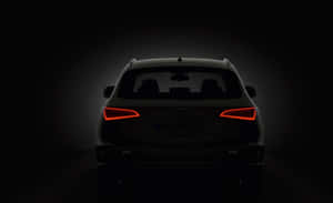 Audi SUV 後視圖，在黑暗工作室環境中帶有發光的紅色尾燈。 — Steam Deck OLED 壁紙