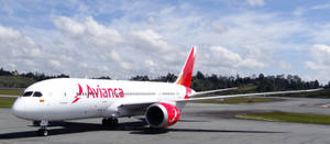Avianca 飛機在跑道上，天空多雲，背景有綠色山丘