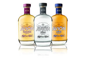 三瓶 Avion 龍舌蘭酒展示在反光的白色表面上。
