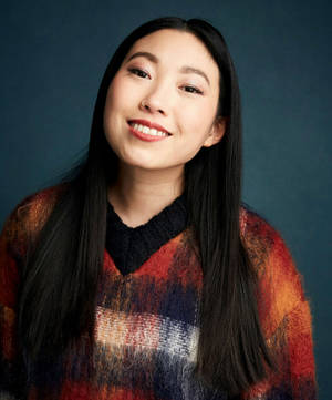 黑髮年輕女性微笑，穿著彩色毛衣，背景為藍色。 — 橙色美學 壁紙