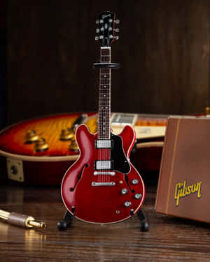 一把紅色Gibson結他展示在支架上，附近有一個結他盒。