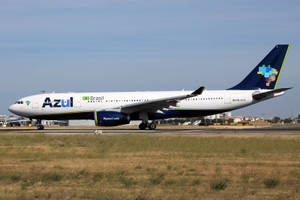 Azul Brazil飛機在乾草和機場建築物的跑道上滑行。