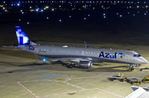 Azul Airlines噴射機在夜間停放在機場停機坪上，燈光璀璨。 — 暗色 壁紙