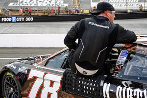 NASCAR車隊成員在賽道上靠在78號賽車上。