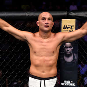 UFC拳手在八角籠中高舉雙臂慶祝勝利。 — 運動 壁紙