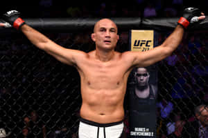 UFC拳手在八角籠內高舉雙臂慶祝勝利。 — 勝利 壁紙