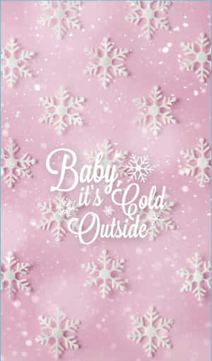 粉紅色背景，白色雪花和草書文字「Baby it's Cold Outside」。
