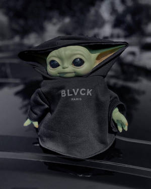 Baby Yoda毛公仔著黑色連帽衛衣，印有BLVCK PARIS字樣，坐喺車頭蓋上。