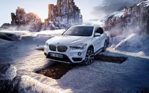 白色BMW SUV在日出時停放在雪地山區。 — Steam Deck OLED 壁紙