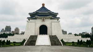 白色中正紀念堂，藍色屋頂和石階，在陰天之下。