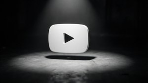 一個白色YouTube播放按鈕在黑暗地板上的聚光燈下。