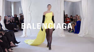 模特兒在 Balenciaga 時裝秀上穿著黃色連衣裙走天橋。