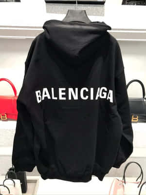 黑色Balenciaga連帽衛衣帶白色標誌，展示在人體模型上，附近有豪華手袋。