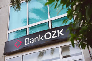 現代建築上的 Bank OZK 招牌，配有棕櫚樹和玻璃窗。