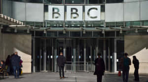 陽光明媚的日子裡，人們在BBC大樓入口附近行走。
