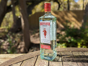 陽光戶外環境中木桌上的必富達氈酒瓶