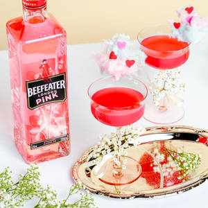 粉紅色氈酒瓶和雞尾酒，飾以棉花糖心和小花，放在金色托盤上。