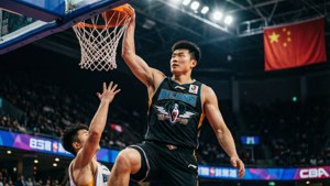 籃球運動員在場館燈光下灌籃，防守球員在附近