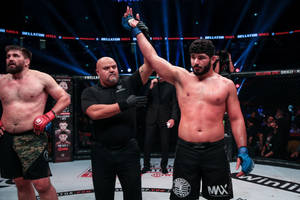 MMA拳手在八角籠中獲勝，裁判舉起他的手。
