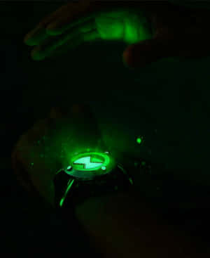 手腕上發光的綠色 Omnitrix 手錶，將光線投射到黑暗中的手上。 — 超級英雄 壁紙