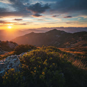 夕陽照耀山脊，金色光芒與暮色天空中的彩色雲朵