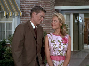 身穿1960年代服裝的男女在屋外相視而笑。