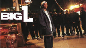 戴帽子和穿外套的男人在夜晚濕漉漉的城市街道上，帶有 'BIG L' 標誌。 — 專輯封面 壁紙