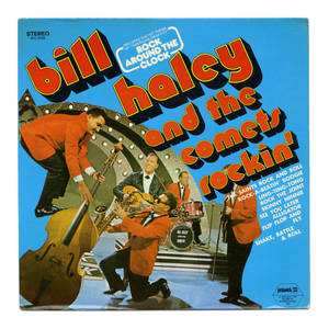 Bill Haley and the Comets 在舞台上穿著紅色西裝表演搖滾樂。