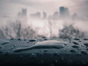 特寫雨滴落在表面上，背景是模糊的城市景觀。