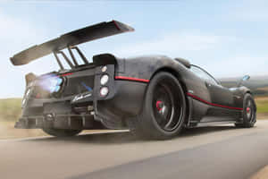 黑色Pagani Zonda跑車在道路上疾馳，帶有紅色點綴和碳纖維細節。 — Surface Laptop 壁紙