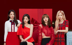 四位穿著紅色節日服裝的女性為節日照片擺姿勢。