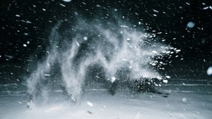 雪在冰冷的爆炸中向上噴發，映襯著黑暗的冬夜天空。