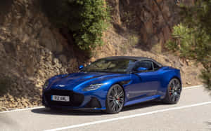 藍色 Aston Martin V12 Vantage 開篷跑車在山路上行駛。 — Steam Deck OLED 壁紙